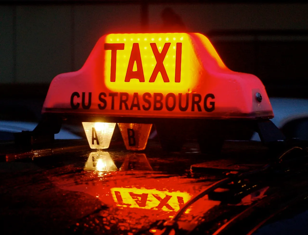 Une enseigne lumineuse de taxi strasbourgeois allumée la nuit, reflétée sur un toit de voiture mouillé